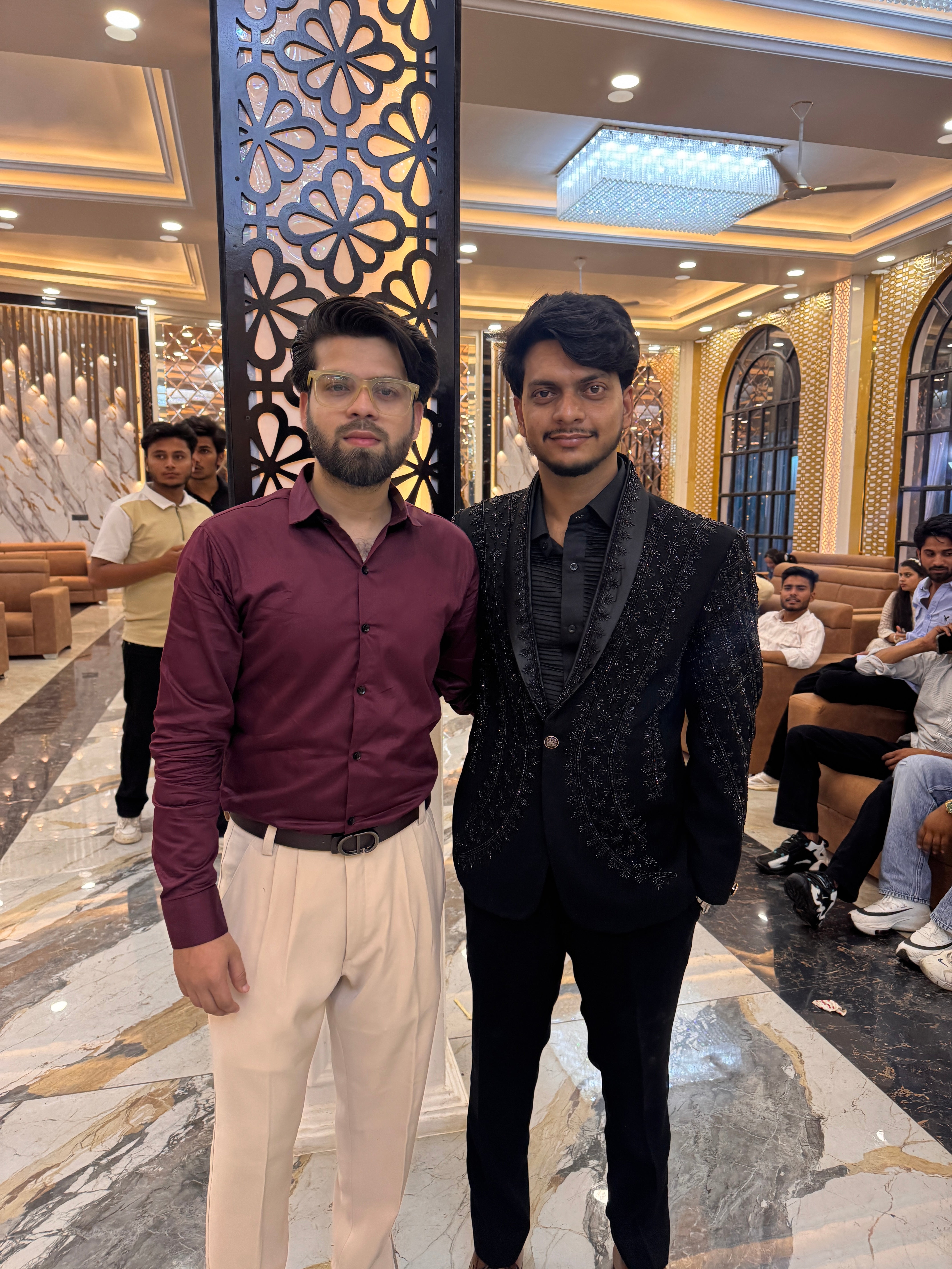 A rear view of the man in the tuxedo, highlighting the intricate hand-painted design on the back of the blazer.

