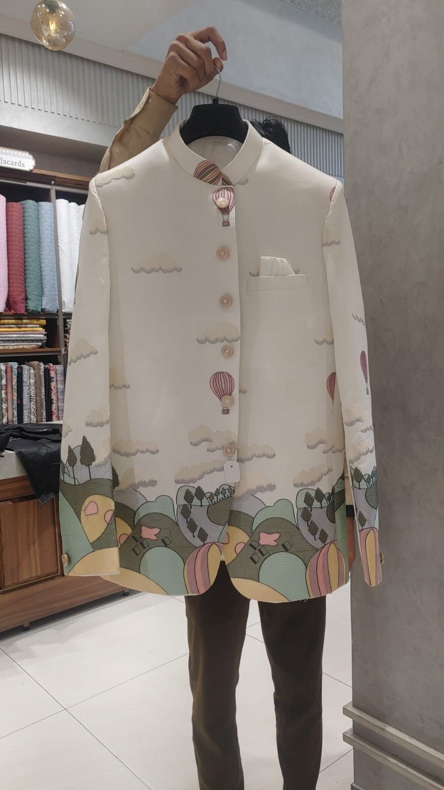 A close-up of the man's face and torso, showing the intricate thread work on the Jodhpuri jacket.