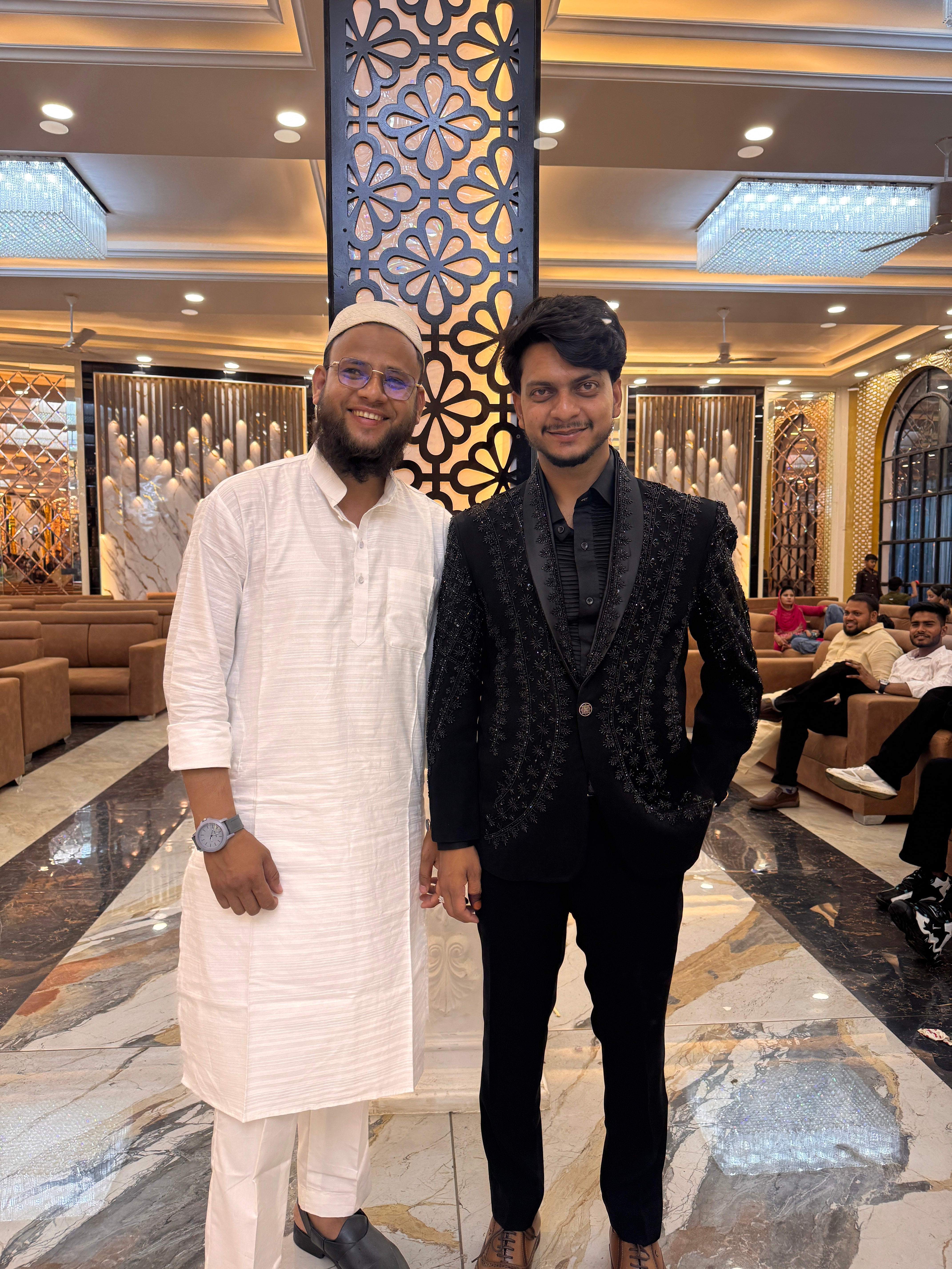 A full-body front view of the man in the hand-painted tuxedo, showing the unique artwork on the blazer and pants.

