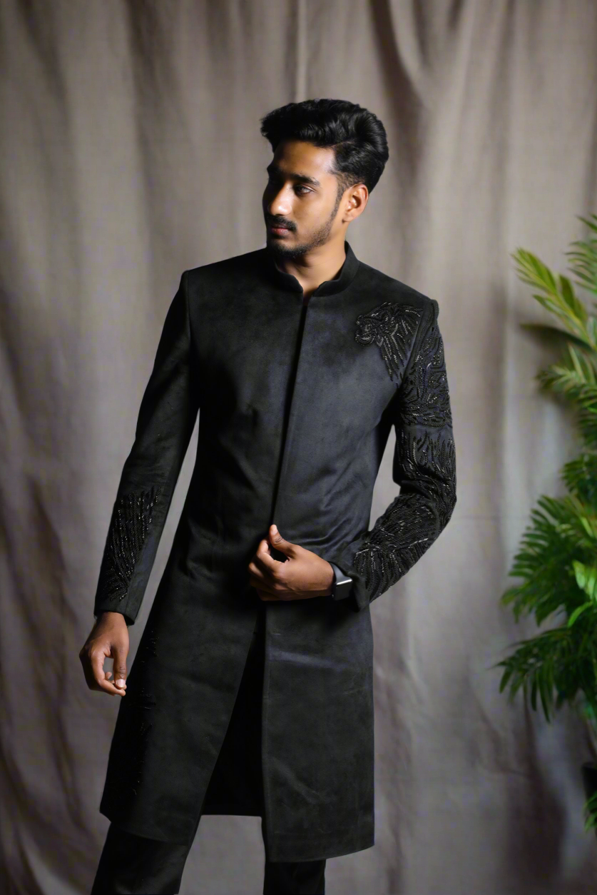Full view of men’s black sherwani with matching pants.
