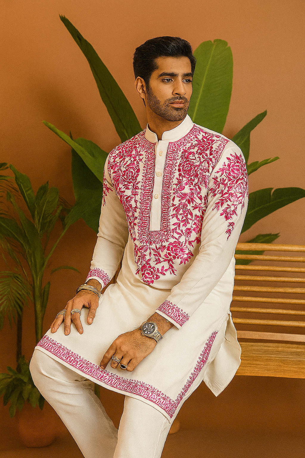 Groom wearing white & pink floral embellished kurta for wedding celebration