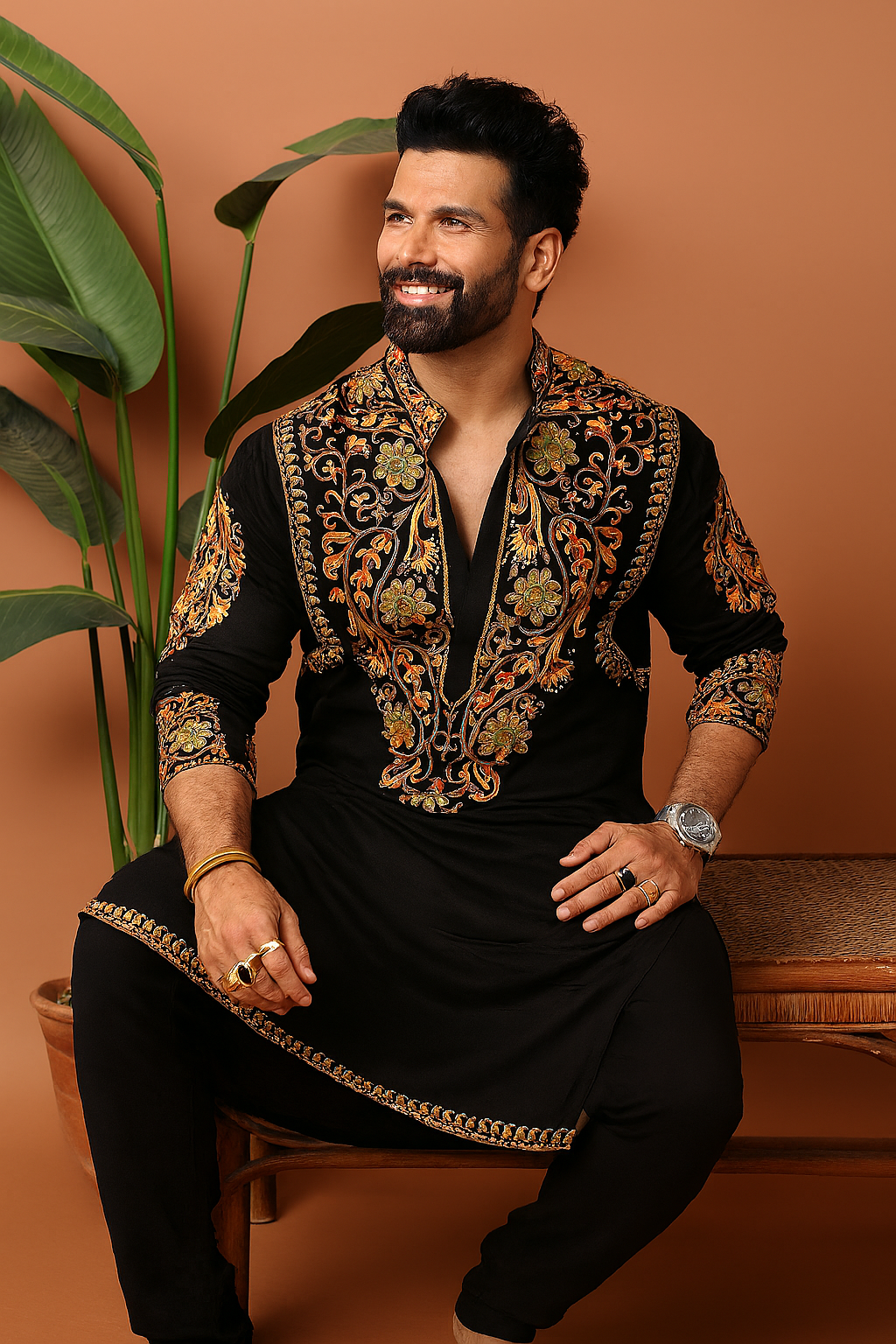 “Model wearing Celebrity Inspired Designer Embellished Kurta Set, sitting pose showcasing intricate gold embellishments and premium fabric”
